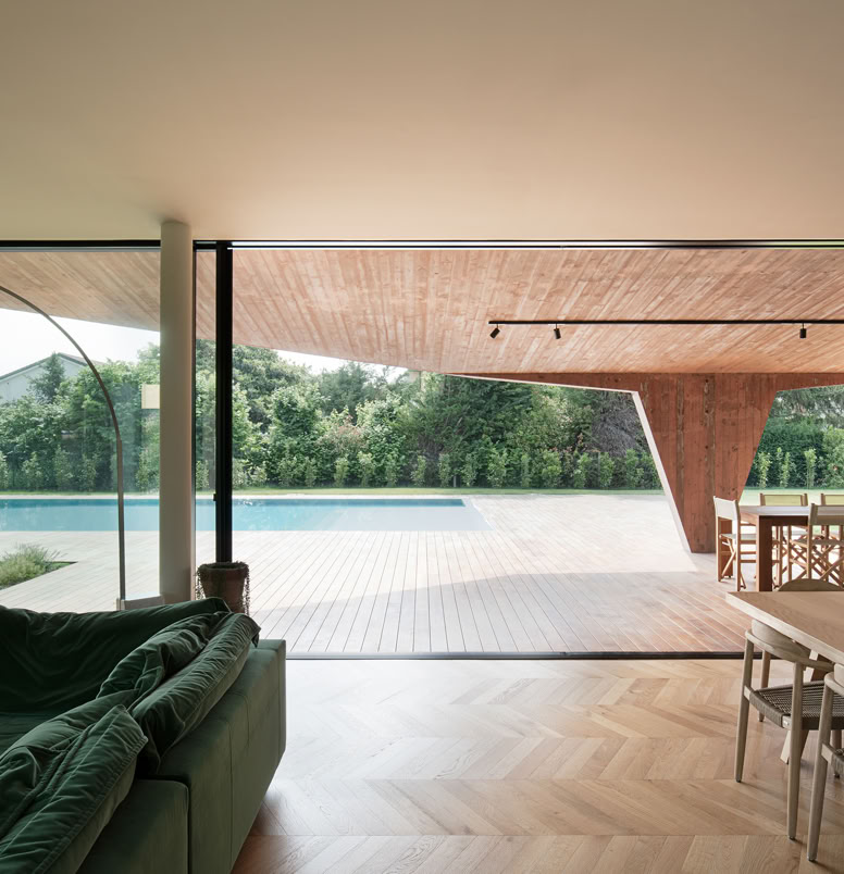 Zona giorno della villa progettata da MIDE architetti che attraverso ampie vetrate permette di godere della vista sulla piscina a sfioro.