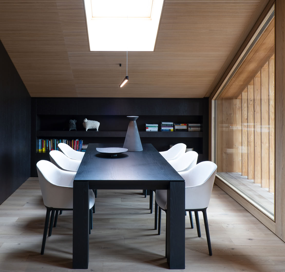 Open-plan dining and kitchen area with black marble peninsula and Dolomites views.