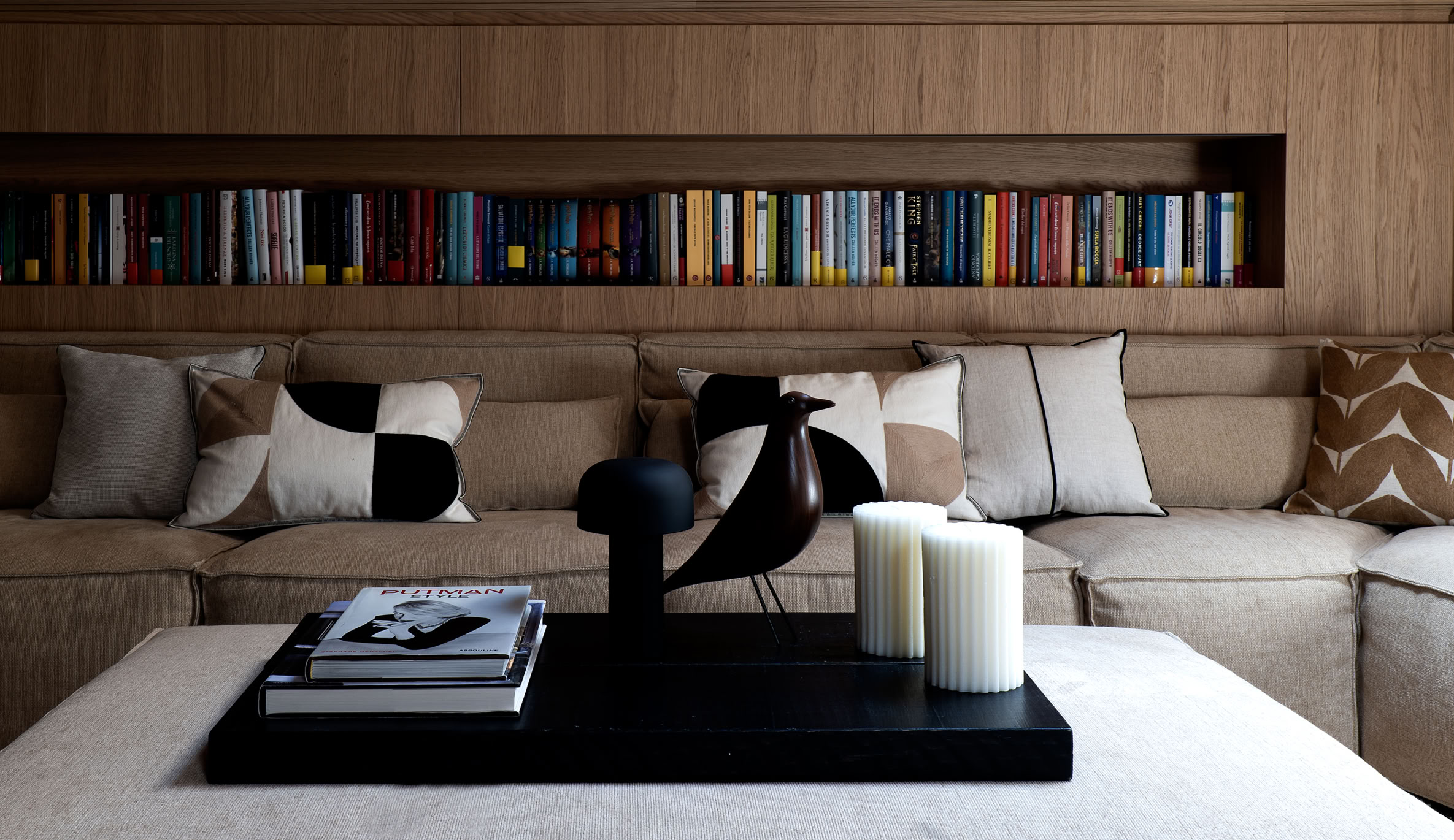 Spacious living room in luxury penthouse Cortina d’Ampezzo with designer sofa, armchairs, natural light, and wooden finishes.