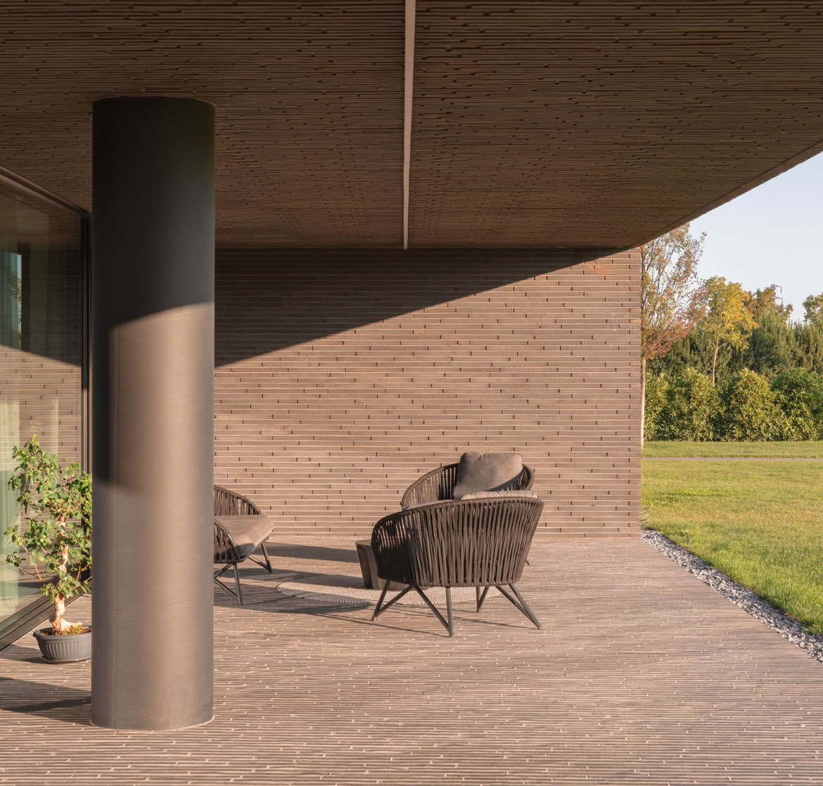 Detail of the outdoor patio of the brick villa set within the park, designed by MIDE architetti.