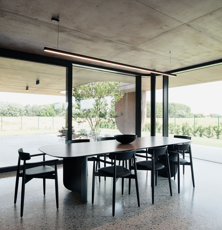 Sala da pranzo della villa progettata da MIDE architetti con grandi vetrate che permettono la vista dell'ampio portico fruibile tutto l'anno.
