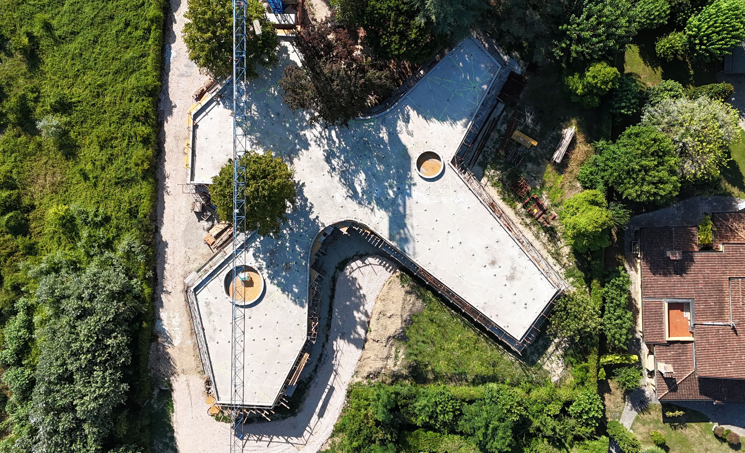 Vista esterna della villa a Selvazzano in costruzione, progettata da MIDE architetti immersa nel verde e disegnata con geometrie pulite che regalano la privacy all'abitazione.