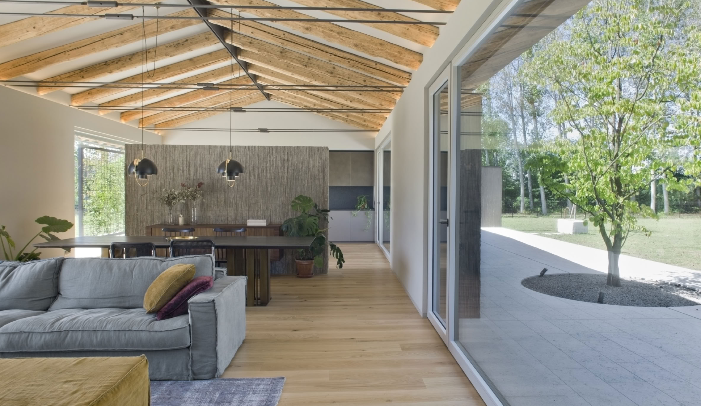 Gli interni della villa contemporanea di MIDE architetti a Noale sono caratterizzati da luce naturale, continuità visiva e materiali materici.