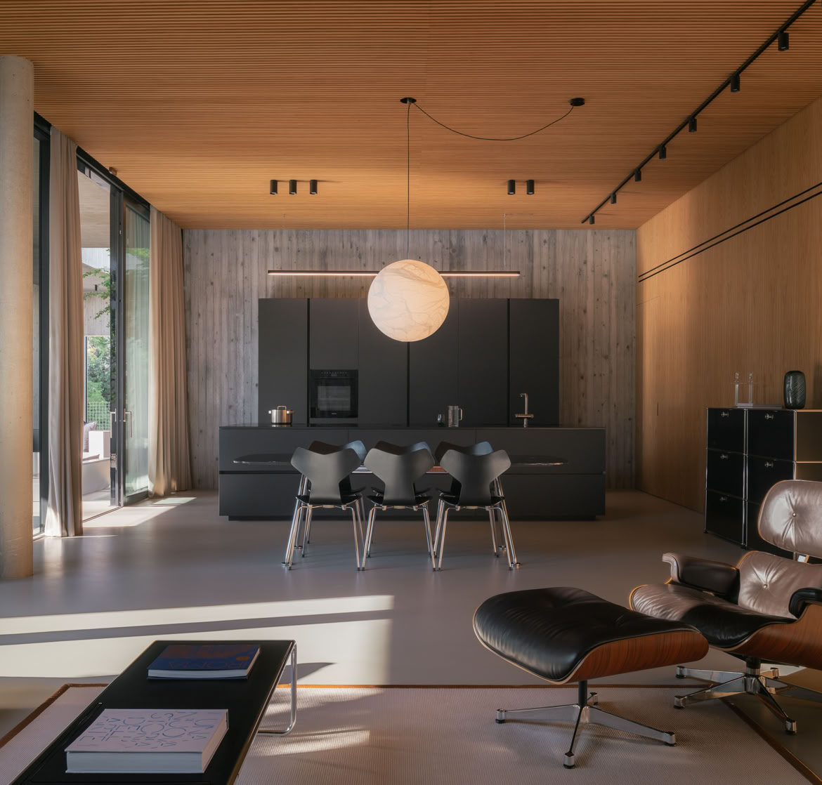 Kitchen seamlessly integrated with the living area through the coherent use of neutral colors and natural materials.