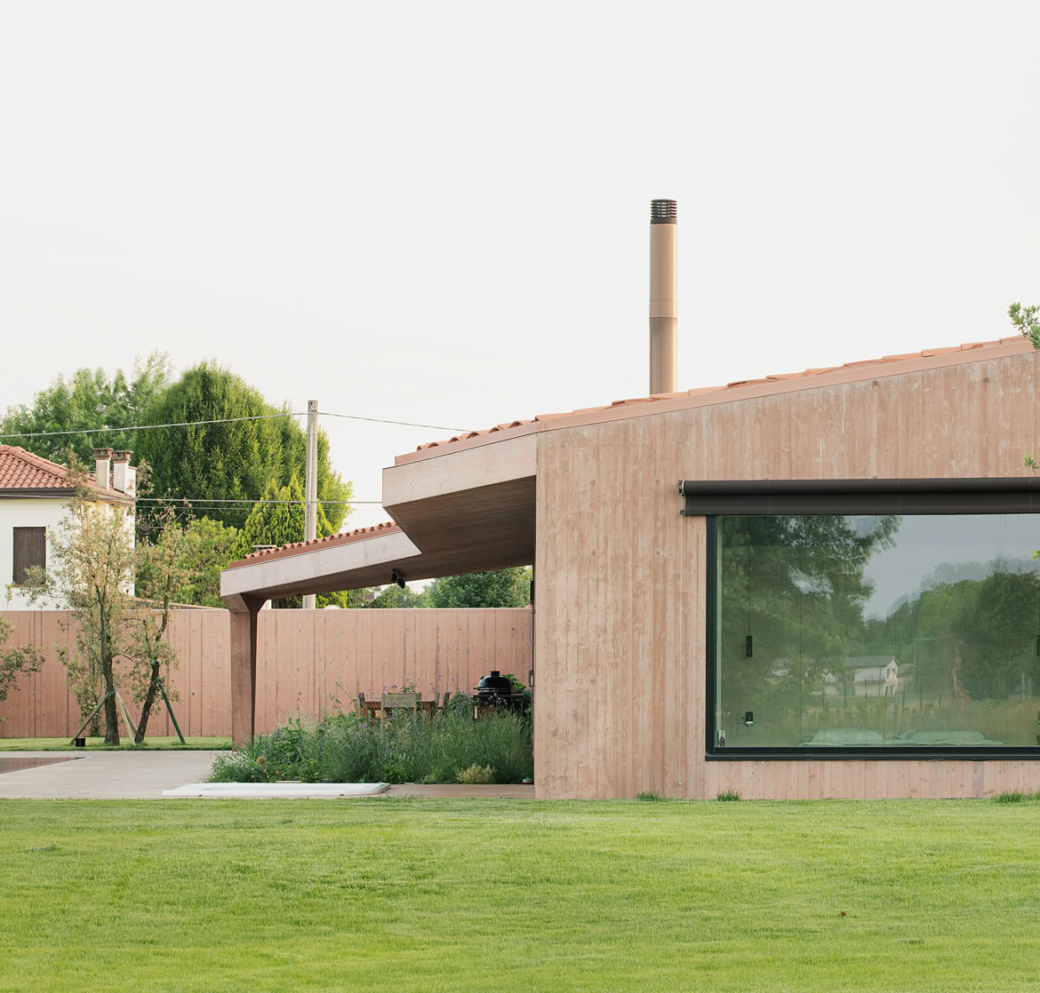 Vista del prospetto laterale della villa con piscina situata a Vigodarzere e progettata da MIDE architetti.
