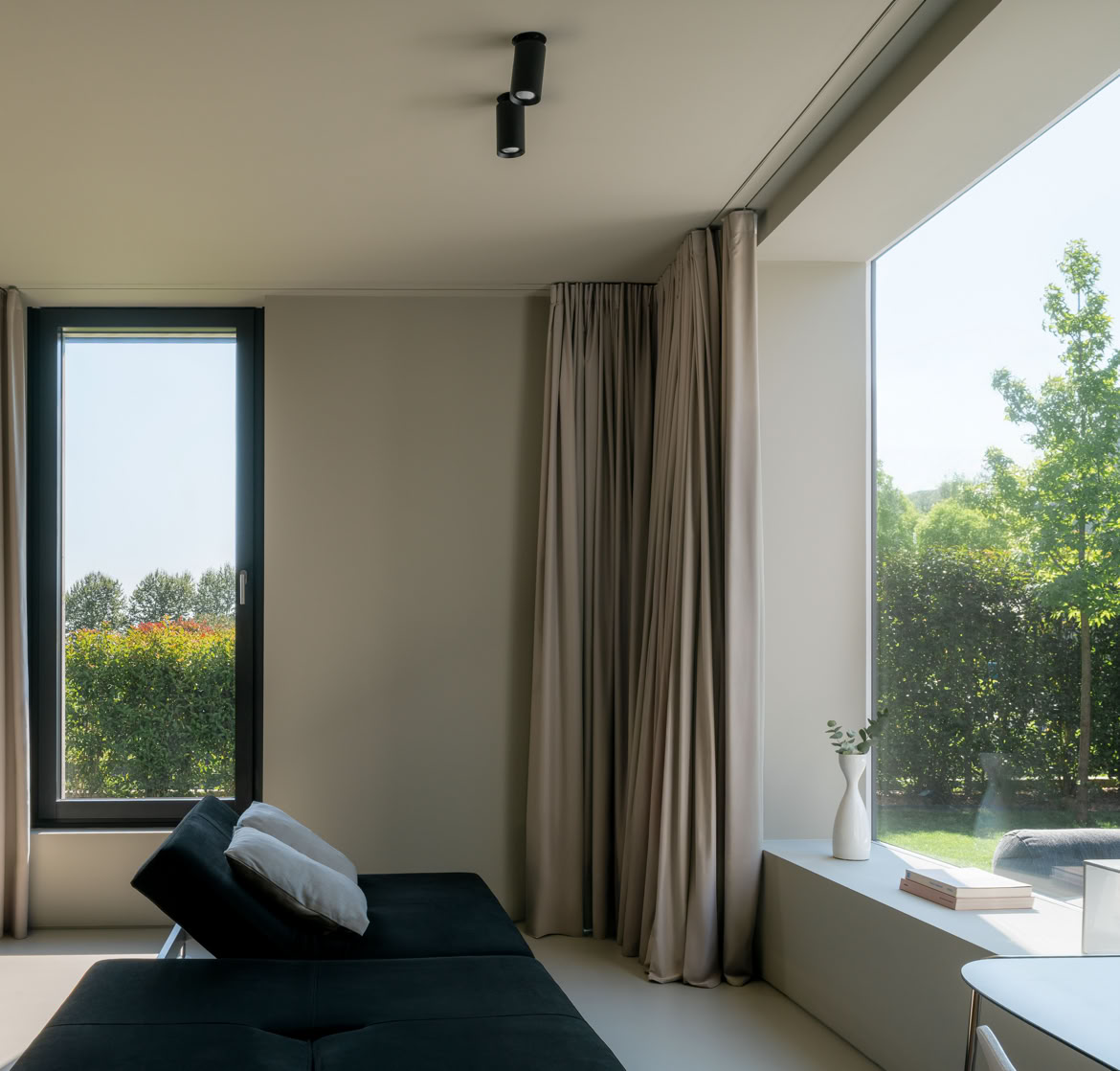 Relaxation and study area designed with expansive glazing to enjoy uninterrupted views of the garden surrounding this home designed by MIDE architetti.