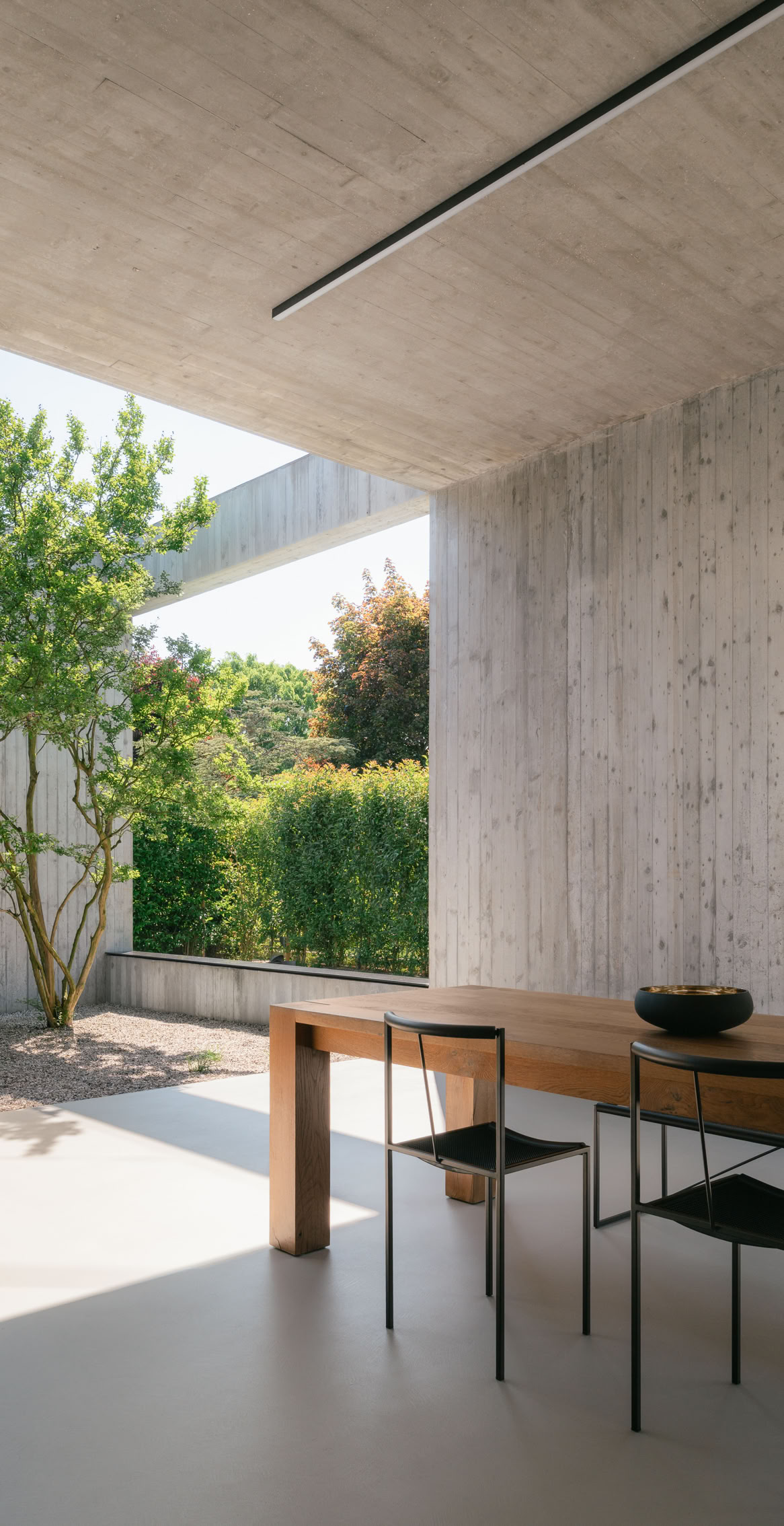 Carefully selected vegetation weaves between the concrete volumes, softening the architectural composition and enhancing its connection with the surrounding landscape.