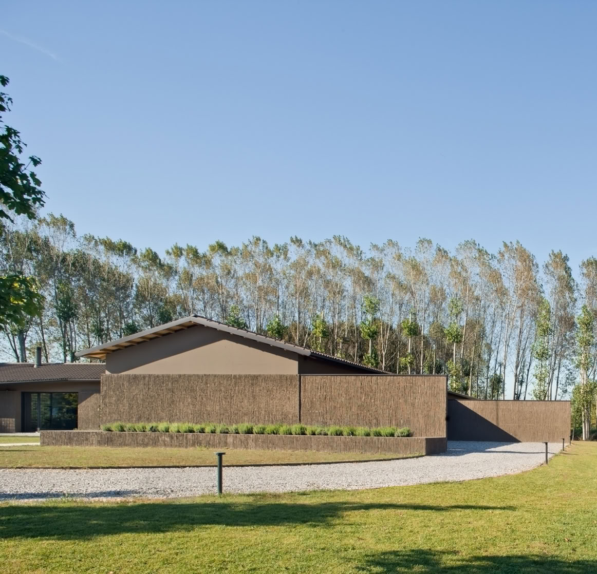 Il volume a un piano della casa progettata da MIDE architetti, con copertura a falde reinterpreta in chiave contemporanea le tradizionali architetture agricole venete.