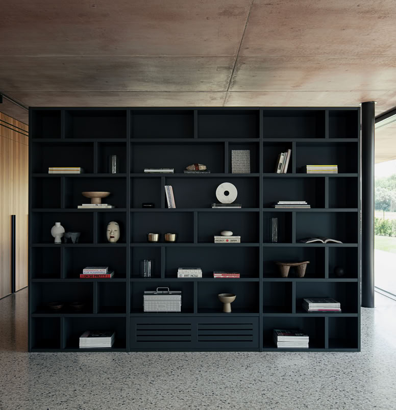 La matericità del calcestruzzo esposto e colorato definisce il carattere monolitico della villa, accentuando la semplicità formale e il forte legame con la luce naturale.