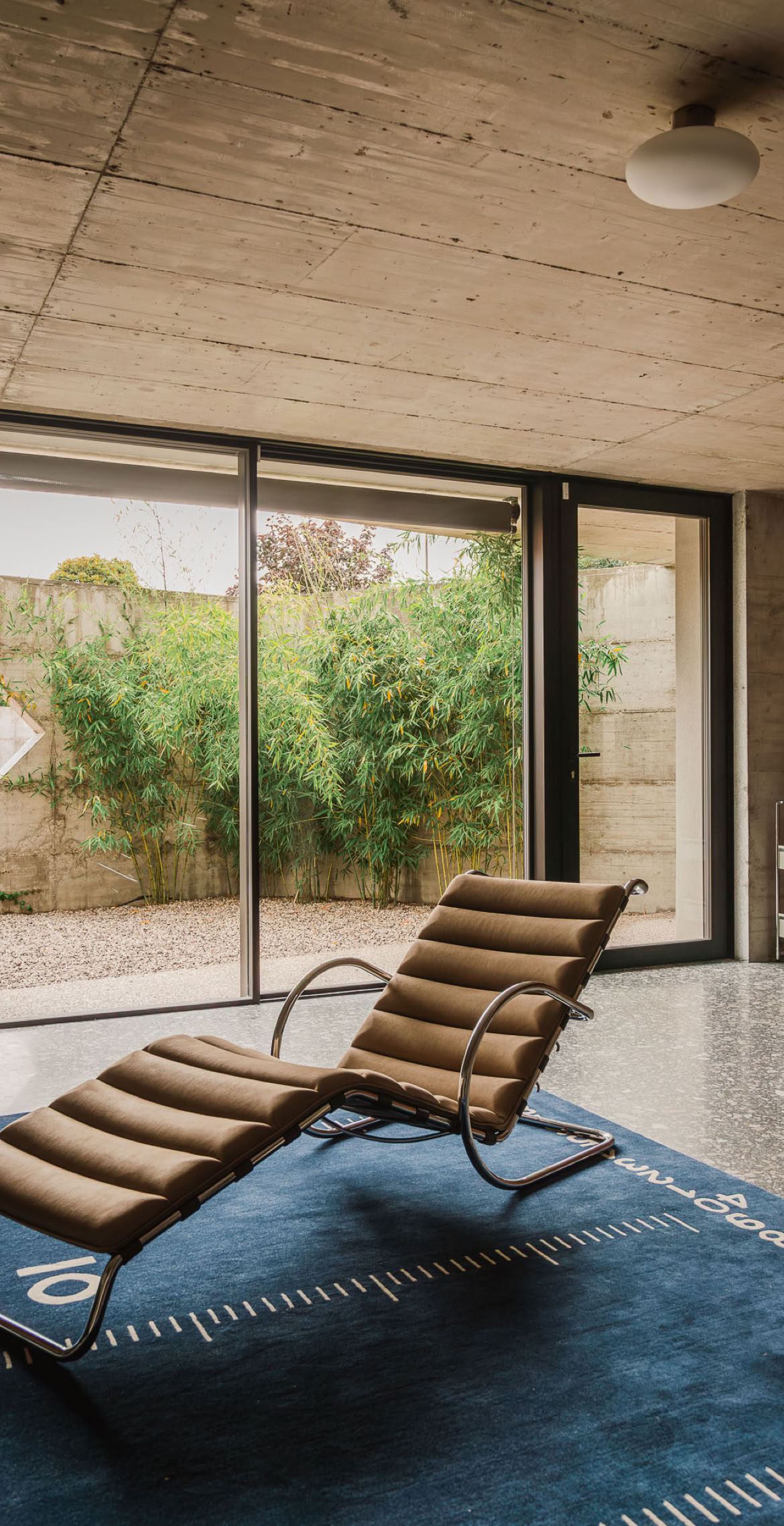 Una casa brutalista con materiali contemporanei sviluppata da MIDE architetti. In foto l'area relax al piano terra con affaccio su corte interna.