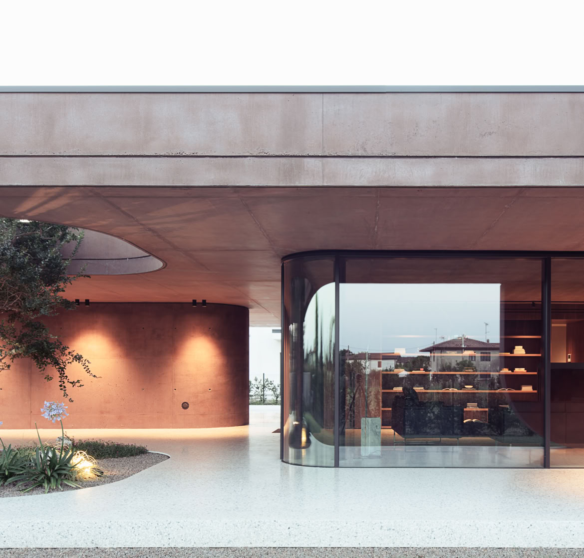 Facciata scenica della villa progettata da MIDE architetti con volumi e aperture che permettono di incorniciare il verde circostante.