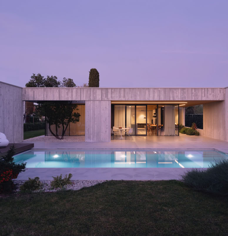 Contemporary single-level villa by MIDE architetti on the Piave River, combining privacy, open-space living, large glass windows, natural materials, and seamless integration with the surrounding landscape.