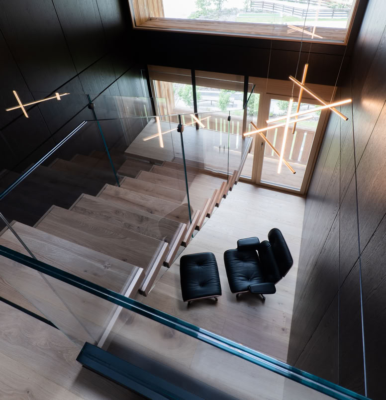 Designer internal staircase connecting sleeping area and living space in contemporary alpine penthouse.
