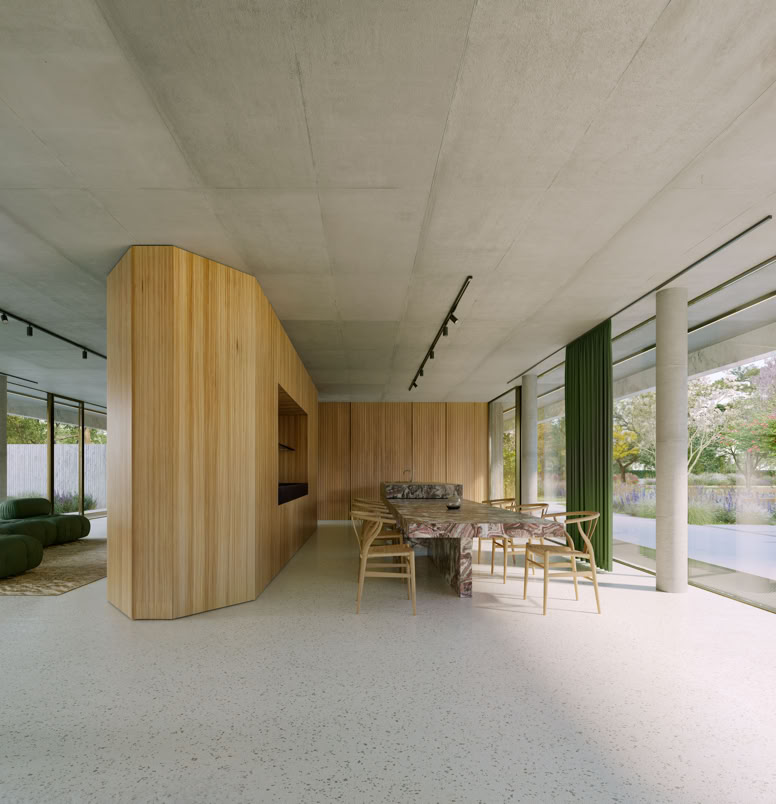 La sala da pranzo, luminosa e aperta sul giardino, è caratterizzata da arredi su misura e materiali contemporanei che creano un ambiente raffinato e accogliente, in continuità con la zona giorno. Villa a Forte dei Marmi.