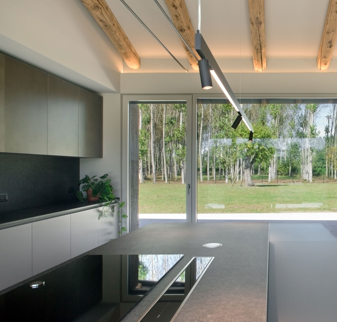 Gli interni della villa contemporanea a Noale si aprono verso il paesaggio, creando un’esperienza abitativa immersiva e naturale.