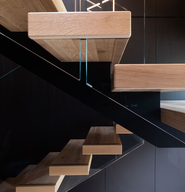 Designer internal staircase connecting sleeping area and living space in contemporary alpine penthouse.